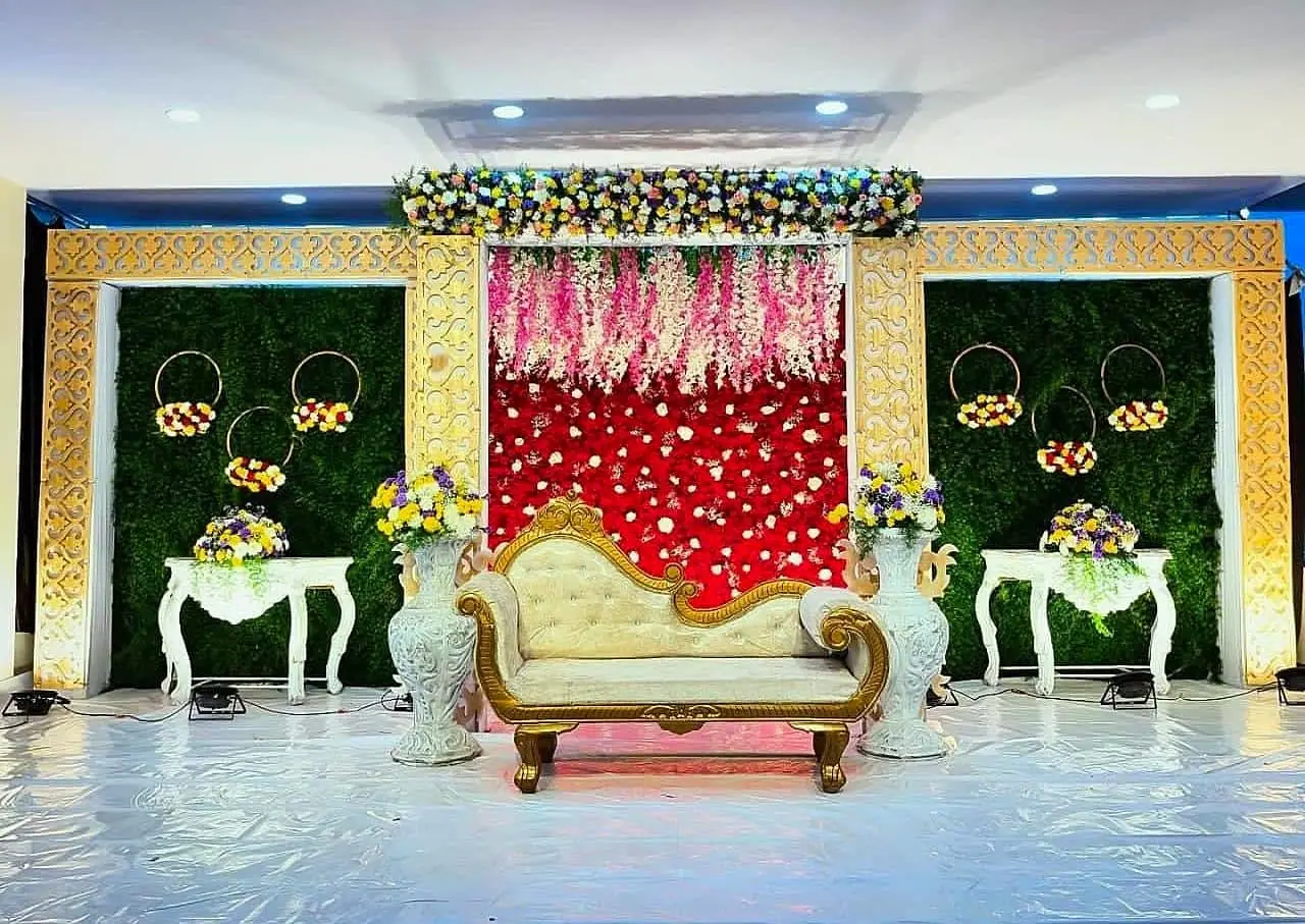 Red and gold reception stage with floral wall