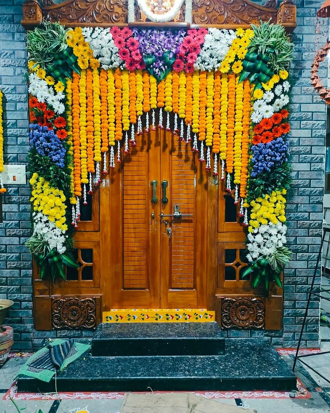 Carved wooden door framed with marigold and flower strands