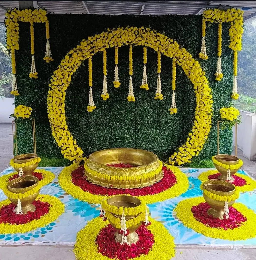 Brass urli and flower rangoli with marigold ring