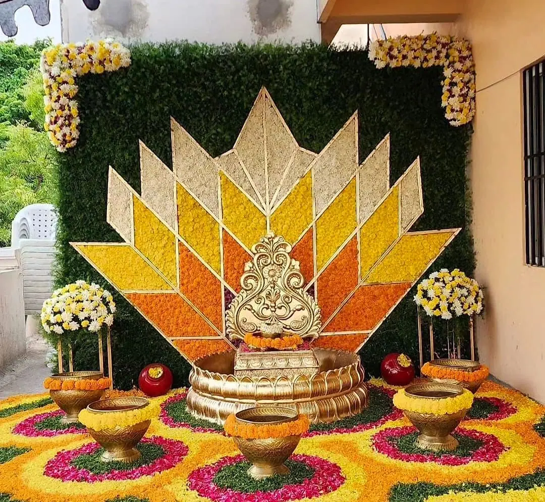 Golden lotus fan backdrop with flower rangoli